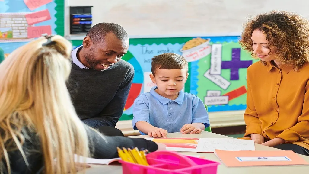 Image of a teacher meeting with a student and their parents for a parent teacher conference.